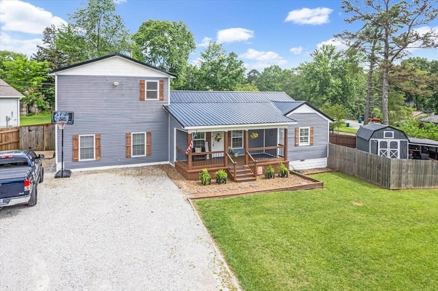 view of front of home with a porch, a storage shed, driveway, an outbuilding, and metal roof
