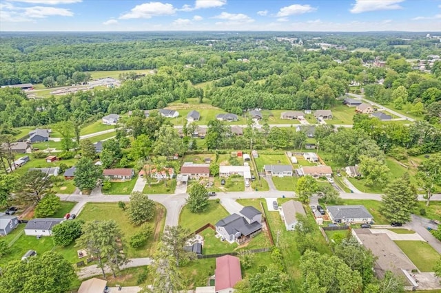 aerial overview of property's location featuring nearby suburban area and a heavily wooded area