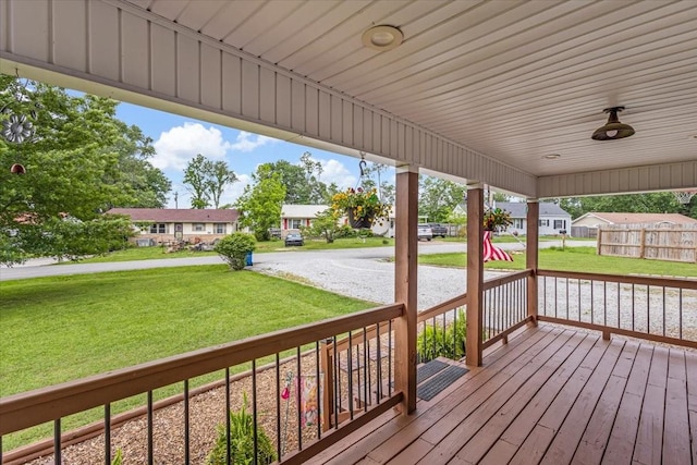 deck with covered porch, a residential view, and a yard
