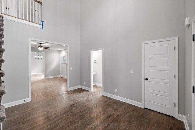 1860 Oakvale Dr, Chattanooga, TN 37421 - unfurnished living room with a high ceiling, dark wood-type flooring, baseboards, a ceiling fan, and a chandelier