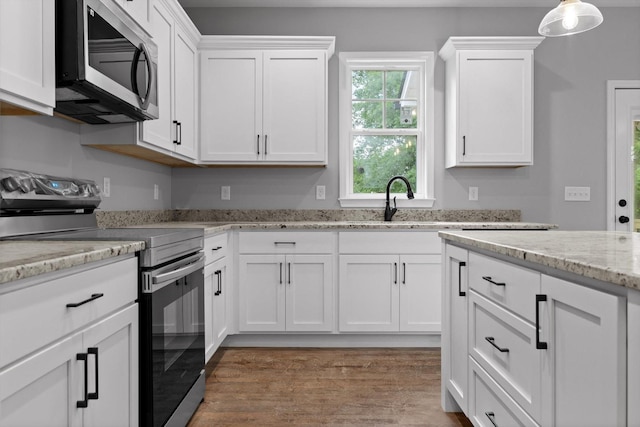 1860 Oakvale Dr, Chattanooga, TN 37421 - kitchen with electric stove, stainless steel microwave, white cabinets, and light wood-style flooring