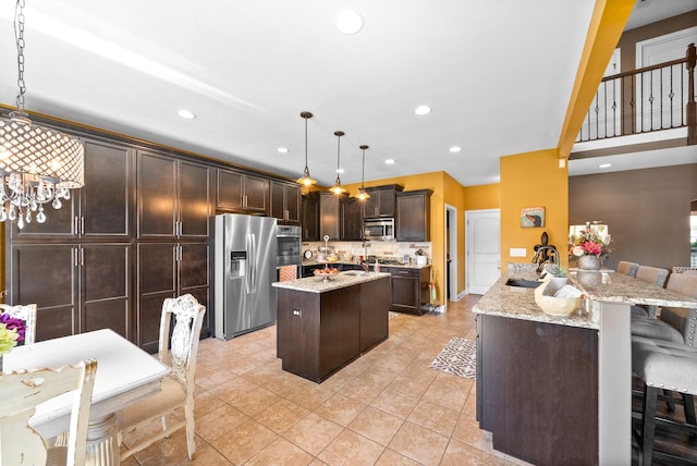 3015 Prince Dr, Clarksville, TN 37043 - kitchen with appliances with stainless steel finishes, a sink, dark brown cabinetry, light stone counters, and recessed lighting
