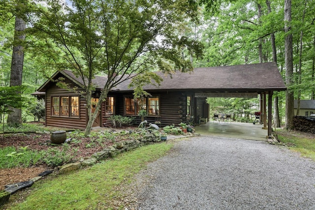 7261 Kingston Rd, Fairview, TN 37062 - cabin with gravel driveway, an attached carport, log exterior, and a shingled roof