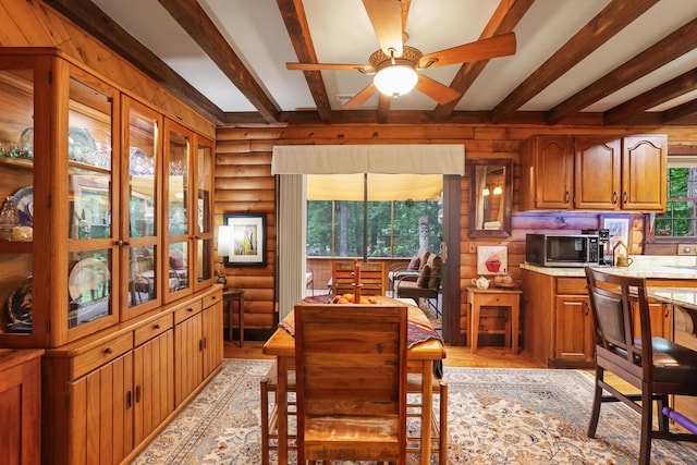 7261 Kingston Rd, Fairview, TN 37062 - dining room with beam ceiling, ceiling fan, light wood-style floors, log walls, and wooden walls