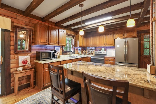 7261 Kingston Rd, Fairview, TN 37062 - kitchen featuring appliances with stainless steel finishes, beam ceiling, a kitchen breakfast bar, light stone countertops, and brown cabinets