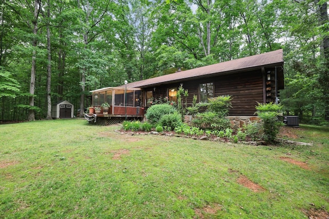 7261 Kingston Rd, Fairview, TN 37062 - view of front facade featuring a sunroom, a shed, log siding, a front yard, and an outbuilding