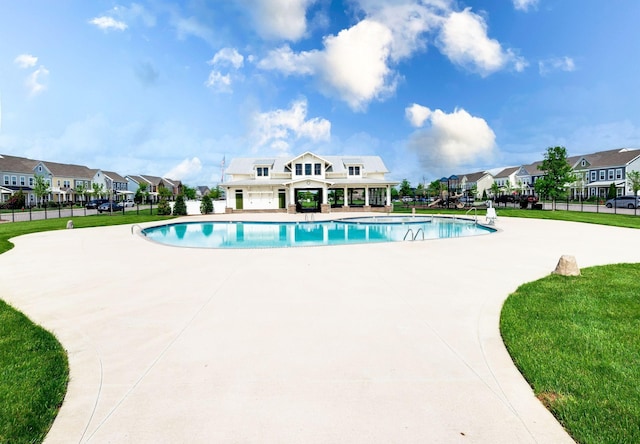 community pool featuring a residential view, fence, and a patio area