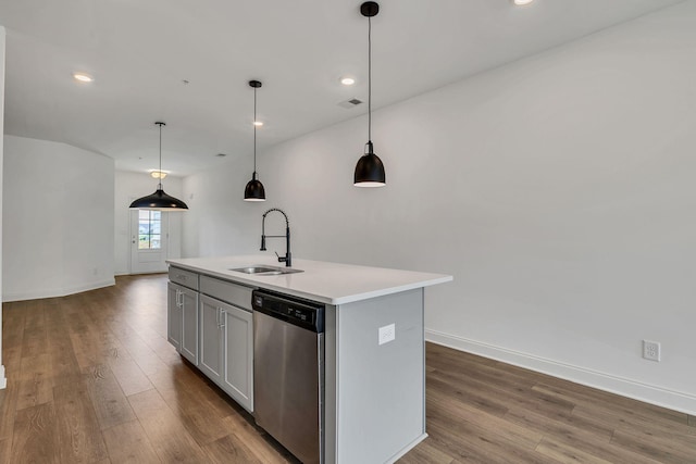 kitchen with stainless steel dishwasher, a sink, wood finished floors, light countertops, and recessed lighting