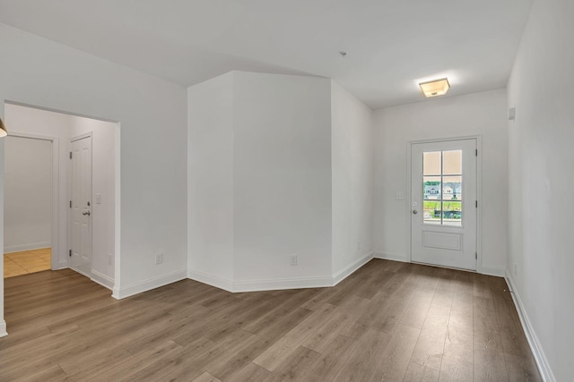foyer entrance with light wood finished floors and baseboards