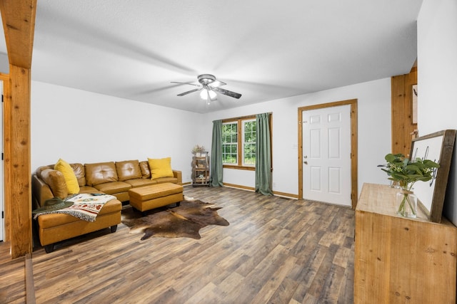 living area with wood finished floors, a ceiling fan, and baseboards