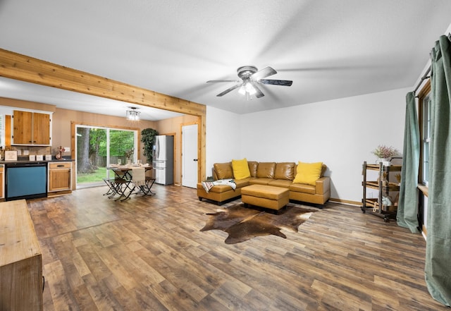 living area featuring wood finished floors, a ceiling fan, and baseboards