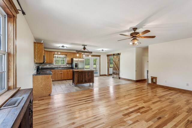 46 Seay Ln, Erin, TN 37061 - kitchen featuring stainless steel refrigerator with ice dispenser, light wood-style floors, a center island, dark countertops, and baseboards