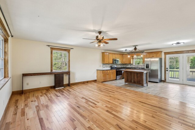 46 Seay Ln, Erin, TN 37061 - kitchen featuring stainless steel appliances, light wood-style flooring, baseboards, and plenty of natural light