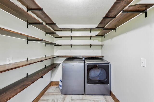 46 Seay Ln, Erin, TN 37061 - clothes washing area featuring washing machine and clothes dryer, baseboards, and a textured ceiling