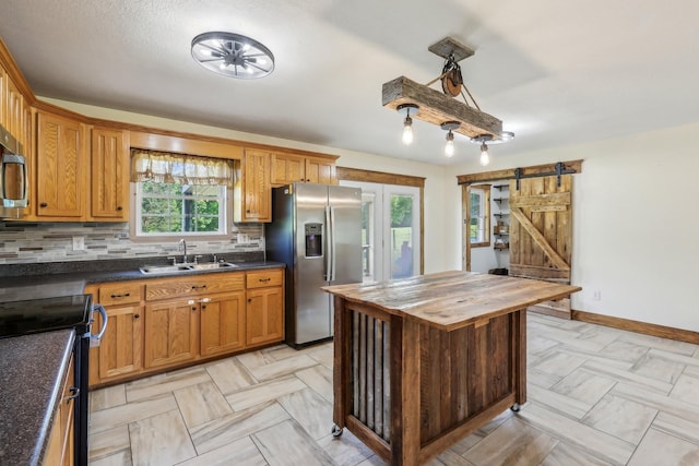 46 Seay Ln, Erin, TN 37061 - kitchen with stainless steel appliances, a sink, butcher block countertops, a barn door, and decorative backsplash