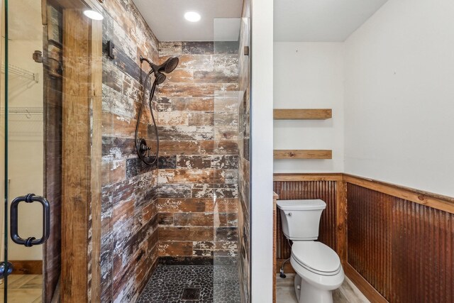 46 Seay Ln, Erin, TN 37061 - bathroom featuring a stall shower, a wainscoted wall, toilet, and wood walls