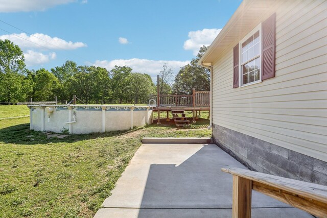 46 Seay Ln, Erin, TN 37061 - view of green lawn with an outdoor pool, a deck, and a patio