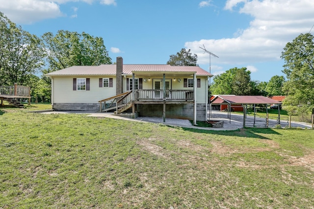 46 Seay Ln, Erin, TN 37061 - back of property featuring a lawn, metal roof, a chimney, and a wooden deck