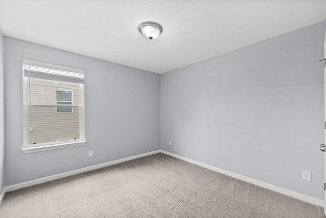 carpeted spare room with baseboards