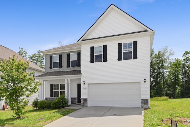 view of front of property with a garage, a front yard, concrete driveway, and board and batten siding