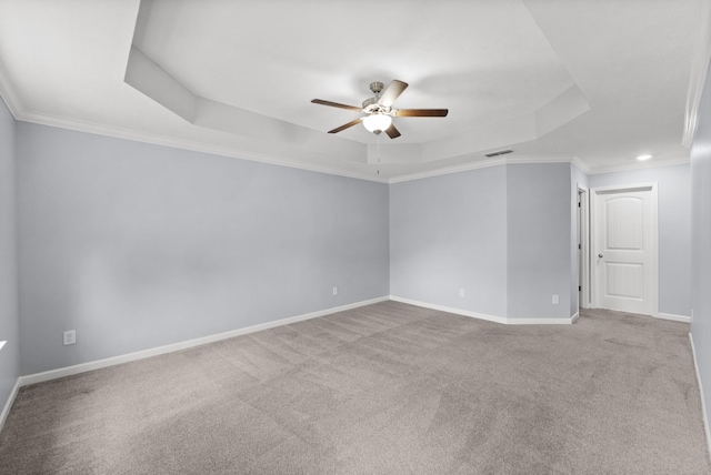 carpeted empty room with a raised ceiling, ceiling fan, baseboards, crown molding, and recessed lighting