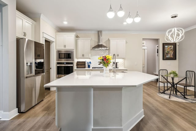 9015 Grayson Cir, Mount Juliet, TN 37122 - kitchen with appliances with stainless steel finishes, wall chimney range hood, crown molding, decorative backsplash, and light wood-style flooring
