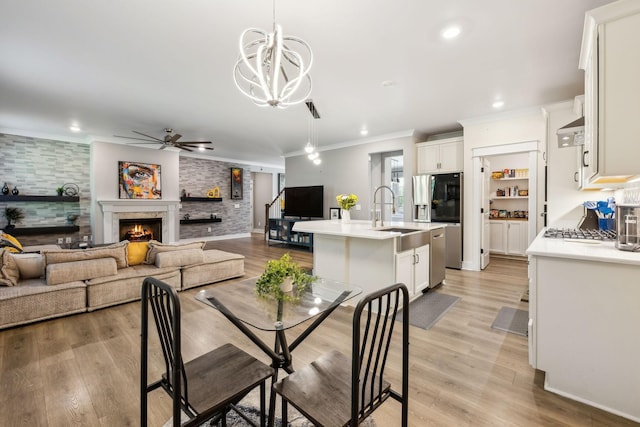 9015 Grayson Cir, Mount Juliet, TN 37122 - dining area featuring a ceiling fan, crown molding, a lit fireplace, recessed lighting, and light wood-style flooring