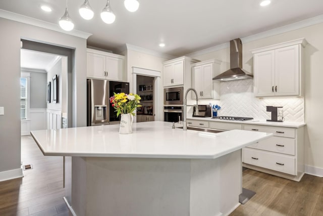 9015 Grayson Cir, Mount Juliet, TN 37122 - kitchen with wall chimney exhaust hood, appliances with stainless steel finishes, crown molding, tasteful backsplash, and wood finished floors