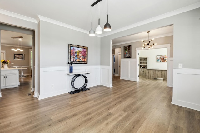 9015 Grayson Cir, Mount Juliet, TN 37122 - unfurnished living room featuring a chandelier, ornamental molding, wainscoting, and light wood finished floors