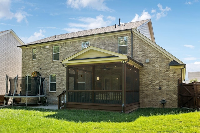 9015 Grayson Cir, Mount Juliet, TN 37122 - rear view of house featuring a trampoline, a sunroom, brick siding, and a yard