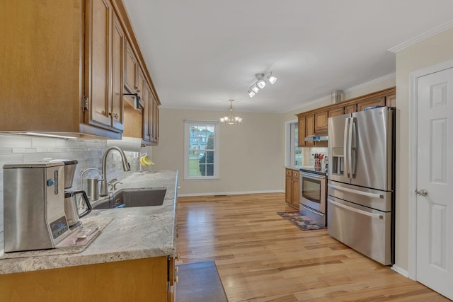 1186 Peebles Dr, Smyrna, TN 37167 - kitchen with appliances with stainless steel finishes, a sink, brown cabinetry, light wood-style flooring, and decorative backsplash