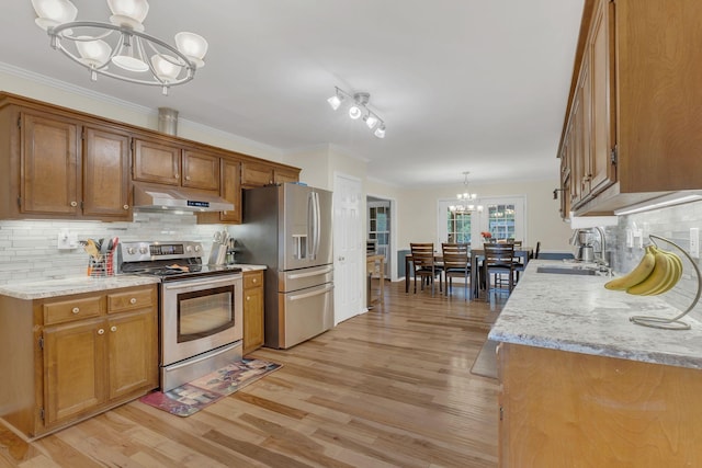 1186 Peebles Dr, Smyrna, TN 37167 - kitchen with appliances with stainless steel finishes, a chandelier, a sink, under cabinet range hood, and light wood-type flooring