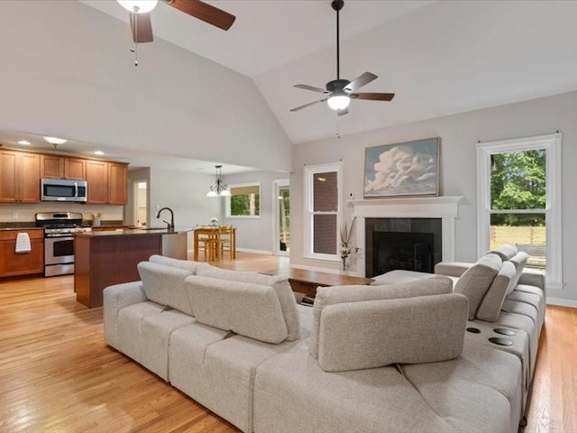 3904 Rowland Rd, Murfreesboro, TN 37128 - living room with ceiling fan, plenty of natural light, light wood-style flooring, high vaulted ceiling, and a tiled fireplace