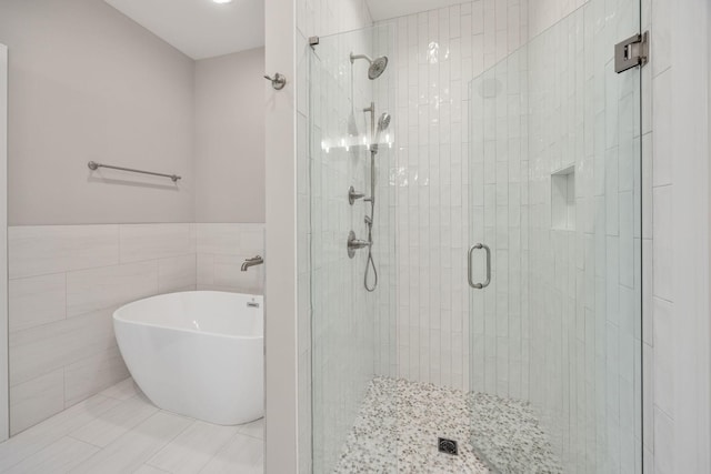 2060 Rylee Way Unit 54, Greenbrier, TN 37073 - bathroom featuring a shower stall, tile walls, a freestanding bath, and a wainscoted wall