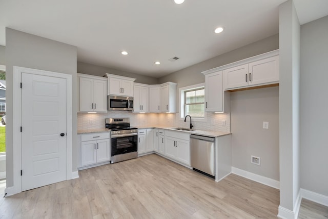 2050 Rylee Way, Greenbrier, TN 37073 - kitchen featuring appliances with stainless steel finishes, a sink, decorative backsplash, white cabinets, and recessed lighting