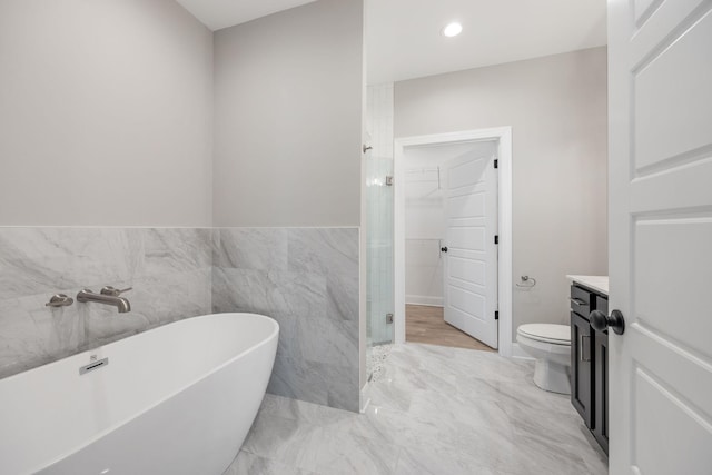 2050 Rylee Way, Greenbrier, TN 37073 - bathroom featuring a freestanding tub, a walk in closet, vanity, a shower stall, and tile walls