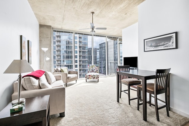 living room with a wall of windows, a ceiling fan, and carpet flooring