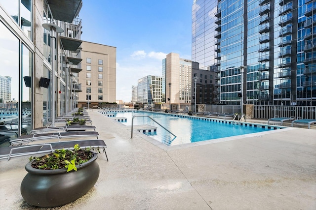 community pool with a city view and a patio