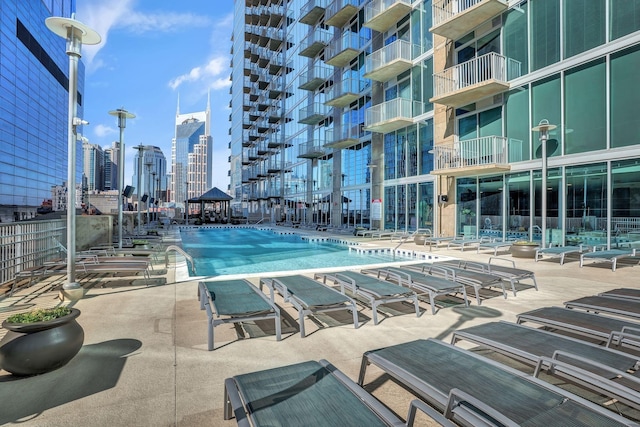 community pool with a skyline view and a patio