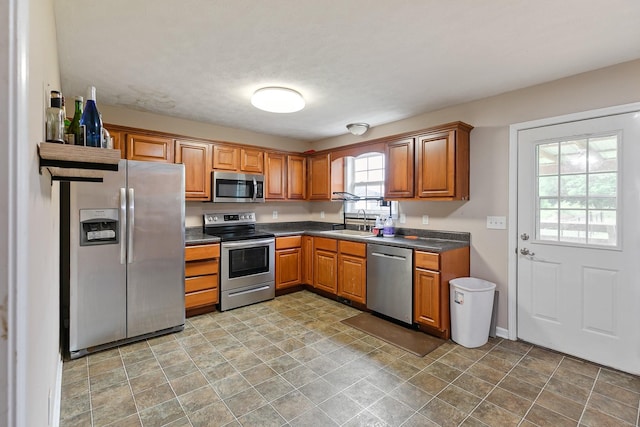 2405 Cason Ln, Lewisburg, TN 37091 - kitchen with appliances with stainless steel finishes, a sink, brown cabinetry, and dark countertops