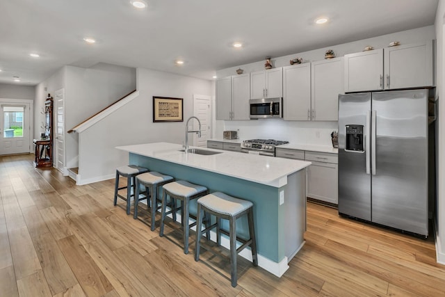 416 Golden Meadow Ln, Hendersonville, TN 37075 - kitchen with stainless steel appliances, a sink, a breakfast bar area, light wood-style floors, and recessed lighting
