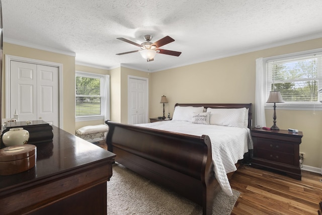 7111 Westview Blvd, Fairview, TN 37062 - bedroom featuring two closets, ornamental molding, wood finished floors, a ceiling fan, and a textured ceiling