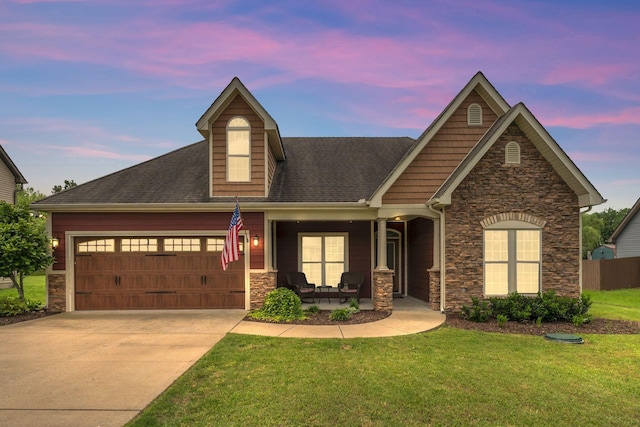 580 Laurel Ln, Murfreesboro, TN 37127 - view of front of property featuring stone siding, an attached garage, a front lawn, roof with shingles, and covered porch