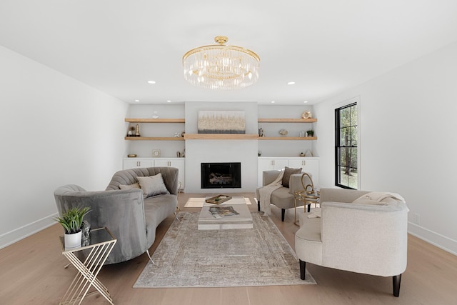living area with wood finished floors, baseboards, and a chandelier