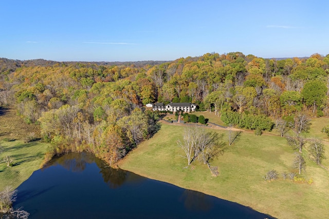 aerial view of property's location featuring a heavily wooded area and a nearby body of water