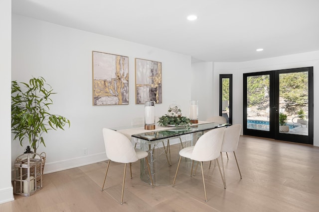 dining room with light wood-type flooring, recessed lighting, and baseboards