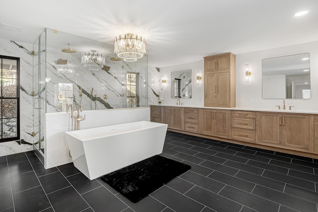 full bathroom featuring a marble finish shower, tile patterned flooring, double vanity, a freestanding bath, and a chandelier