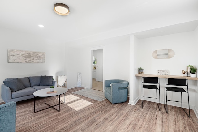 living area with wood finished floors, baseboards, and recessed lighting