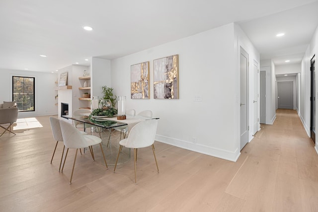 dining room with light wood finished floors, recessed lighting, and baseboards