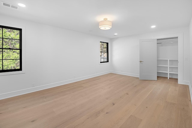 unfurnished bedroom featuring light wood-style floors, baseboards, recessed lighting, and a closet